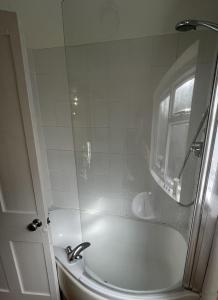 倫敦的住宿－Beautiful ground floor garden flat，白色的浴室设有浴缸和水槽。