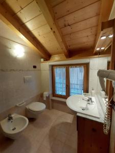 a bathroom with a white sink and a toilet at Agritur Widmann in Coredo