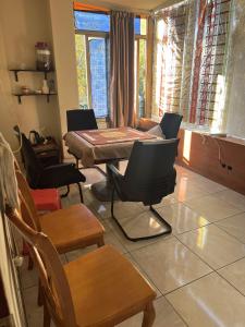 Habitación con sillas, mesa, mesa y sillas. en Shengtang Business Hotel en Johannesburgo
