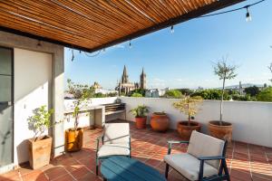 a patio with two chairs and a couch on a roof at Loft con Terraza privada, vista al Expiatorio in Guadalajara