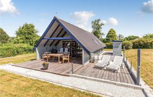 スラーエルセにあるAmazing Home In Slagelse With 3 Bedrooms And Wifiの小さなキャビン(木製デッキ、椅子付)