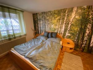 a bedroom with a bed with a mural of trees at Rossatz 69 in Rossatz