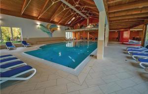 a large swimming pool in a building with blue chairs at Awesome Apartment In St,georgen Am Kreischb, With Sauna, Wifi And Indoor Swimming Pool in Sankt Lorenzen ob Murau