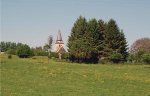 una iglesia con un campanario en un campo con árboles en Gorgeous Home In Romery With Kitchen, en Romery