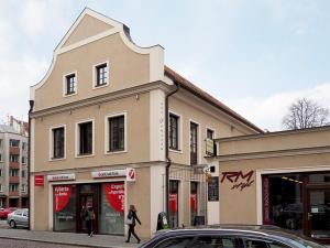 a woman walking down a street in front of a building at Pension Harmonie in Kolín