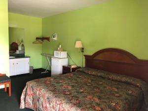 a hotel room with a bed and green walls at Ranch House Motel Marksville in Marksville