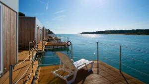 una cubierta de un barco con una silla en el agua en Marina Uno Floating Resort en Lignano Sabbiadoro