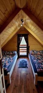 Cette chambre mansardée comprend 2 lits et une fenêtre. dans l'établissement Trzy Szczyty-Wysoka, à Grywałd