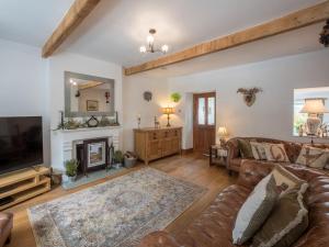 a living room with a couch and a fireplace at Harpers Cottage in Barrowford