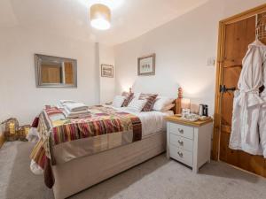 a bedroom with a bed and a wooden door at Harpers Cottage in Barrowford