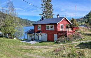 a red house on a hill next to a body of water at Fjellbu in Vråliosen