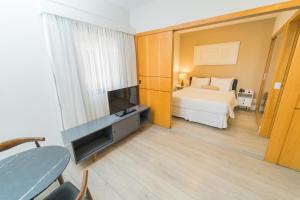 1 dormitorio con 1 cama y TV en una habitación en Hampton Park São Paulo Jardins, en São Paulo
