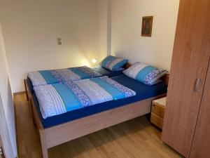 a bed with blue sheets and pillows in a room at Ferienwohnungen Gmeiner in Bad Endorf