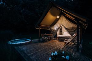 a tent with a bed and a tub on a deck at Luxury vineyard resort Chateau Ramšak in Maribor