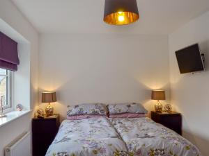 a bed in a bedroom with two night stands and two lamps at Shepley Mews in Glossop