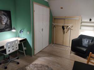 um quarto com uma secretária, uma cadeira e um armário em Pink House Room#1 Stockholm em Estocolmo