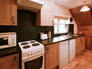 a kitchen with a white stove top oven next to a sink at Yarlington Mill in Ledbury