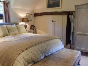 ein Schlafzimmer mit einem großen Bett und einer Tür in der Unterkunft Chapel Cottage, in Holmbury Saint Mary