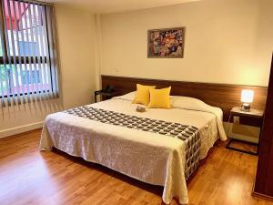 a bedroom with a large bed with yellow pillows at Star Suites México in Mexico City