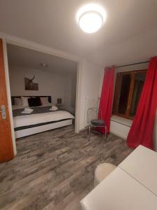 ein Schlafzimmer mit einem Bett und einem roten Vorhang in der Unterkunft LES TOURISTES in Le Chatelard