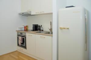 Una cocina con un refrigerador blanco y un fregadero. en White Lotus Apartment, en Viena