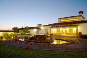 a backyard with a fountain in front of a house at Vila Gale Alentejo Vineyard - Clube de Campo in Albernoa