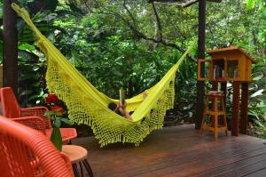 a person sleeping in a hammock on a deck at Pousada Casa Viva a Vida in Lençóis