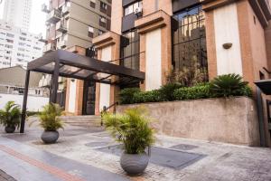 a building with potted plants in front of it at Hampton Park São Paulo Jardins in Sao Paulo