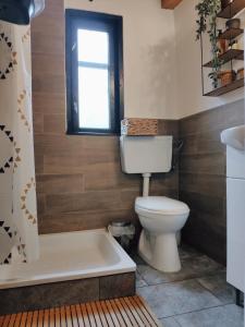 La salle de bains est pourvue de toilettes, d'une baignoire et d'une fenêtre. dans l'établissement Cuib din Fagaras, à Avrig