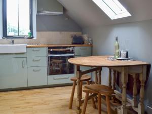 a kitchen with a wooden table and a sink at Fishermans Lodge in Highpeak Junction