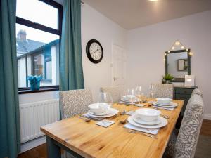 uma mesa de jantar com cadeiras e um relógio na parede em Freville Cottage em Shildon