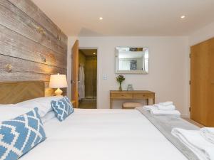 1 dormitorio con 2 camas blancas y pared de madera en Far Cliffs, en St Ives