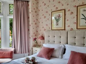 a bedroom with a white bed with pink floral wallpaper at Georges Place in York