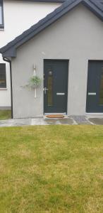 a house with a black door and a plant in a window at Luxurious First Floor Flat in Dornoch