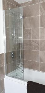 a shower with a glass door in a bathroom at Luxurious First Floor Flat in Dornoch