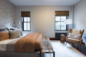 a bedroom with a large bed and a chair at E10-3 3BR Designer Townhouse in New York