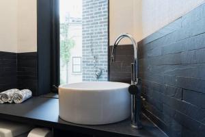 a bathroom with a white sink on a black counter at E10-3 3BR Designer Townhouse in New York