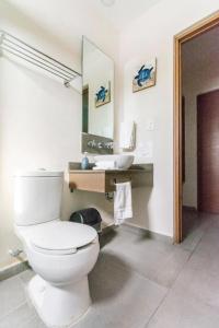 uma casa de banho com um WC branco e um lavatório. em Viento Suites Cancún em Cancún