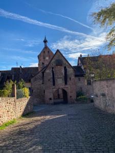 an old stone building with a tower on a street at Riquewihr centre historique in Riquewihr