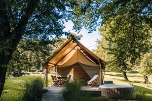 ein Zelt mit Stühlen und einem Tisch auf einem Feld in der Unterkunft Luxury vineyard resort Chateau Ramšak in Maribor