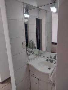 Baño blanco con lavabo y espejo en Casa en Mendoza en Godoy Cruz