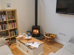 uma sala de estar com um fogão a lenha em Blyth Green Stable em Long Stratton