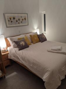 um quarto com uma grande cama branca com almofadas em Former Romsey Brewery House em Romsey