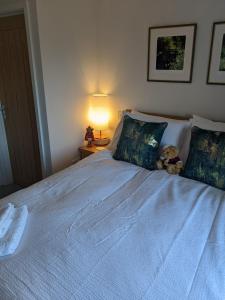 a bed with a teddy bear sitting on top of it at Former Romsey Brewery House in Romsey