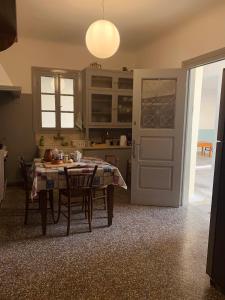 een keuken met een tafel met stoelen en een deur bij Casa Azul in Spáta