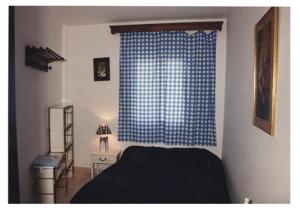 a bedroom with a bed and a blue window at Mar De Cunit in Cunit