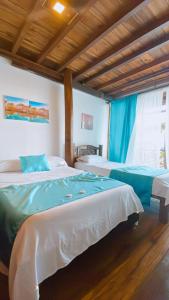 a bedroom with two beds with blue and white sheets at Cabaña The Sunset in Santa Marta