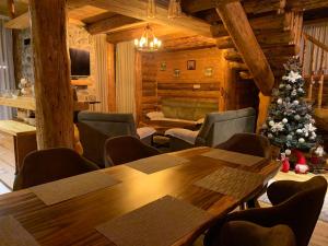 a room with a wooden table and a christmas tree at Alpine House in Žabljak