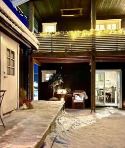 una casa con un patio cubierto con mesa y sillas en New apartment near the lifts tourist center Trysil, en Trysil 18 fotos más