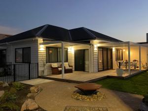 a house with a deck with a bench in the yard at 4BR Waterfront - Skippers Quarterdeck in Lakes Entrance